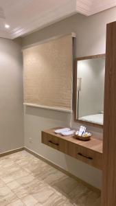 a bathroom with a large mirror and a sink at Izdihar Dalis Suites in Quai +29 photos