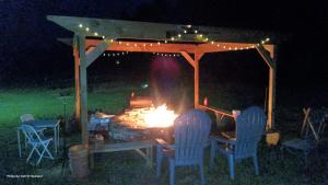 a fire pit under a gazebo at night at Cozy Camper at Howland's Hideout in Sampson