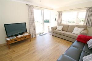 a living room with a couch and a flat screen tv at 1 Bed in Gower oc-hh80 in Oxwich