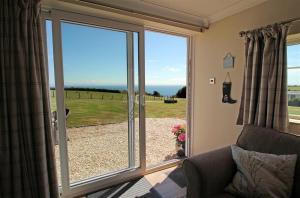 a living room with a large sliding glass door at 1 Bed in Gower oc-hh80 in Oxwich +7 photos