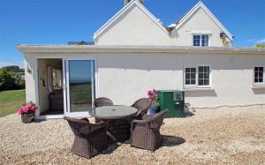 a patio with a table and chairs in front of a house at 1 Bed in Gower oc-hh80 in Oxwich