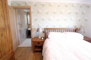 a bedroom with a white bed and a mirror at 1 Bed in Gower oc-hh80 in Oxwich