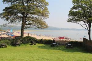 a park with benches and people on a beach at 1 Bed in Gower oc-hh80 in Oxwich