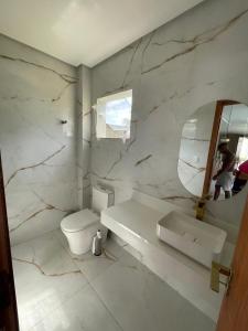 a bathroom with a toilet and a sink and a mirror at Casa Itacimirim in Camacari