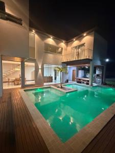 a large swimming pool in a house at night at Casa Itacimirim in Camacari +19 photos