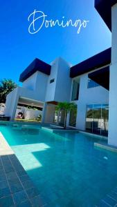 a house with a swimming pool in front of it at Casa Itacimirim in Camacari