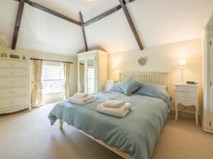 a bedroom with a large bed with towels on it at 2 Bed in Dersingham oc-kt082 in Dersingham
