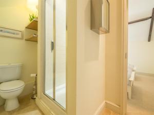 a bathroom with a toilet and a glass shower door at 2 Bed in Dersingham oc-kt082 in Dersingham