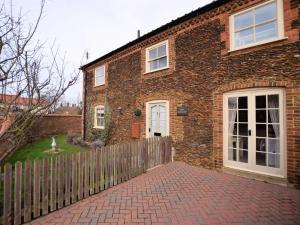 a brick house with a fence in front of it at 2 Bed in Dersingham oc-kt082 in Dersingham