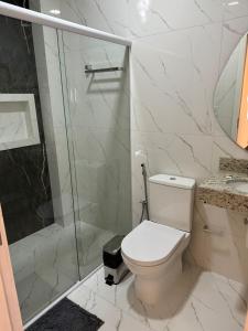 a bathroom with a toilet and a glass shower at Pousada nascer do sol in Portalegre