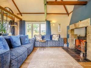 a living room with a blue couch and a fireplace at 3 Bed in Richmond oc-86747 in Gilling