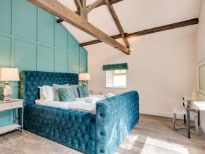 a blue bed in a room with a blue couch at 3 Bed in Richmond oc-86747 in Gilling