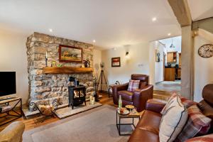 a living room with a stone fireplace and leather furniture at 2 Bed in Bolam oc-b29967 in Ingleton