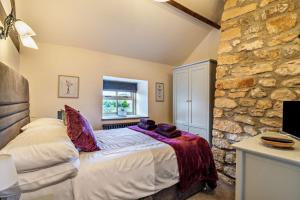 a bedroom with a bed and a stone wall at 2 Bed in Bolam oc-b29967 in Ingleton