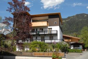 a house in the mountains with a balcony at Gästehaus Maier in Kitzbühel