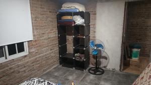 a black book shelf in a room with a fan at Finca Santiago in San Miguel del Monte