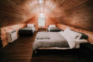 a room with two beds in a log cabin at Camp Hudson Pines in Corinth +58 photos