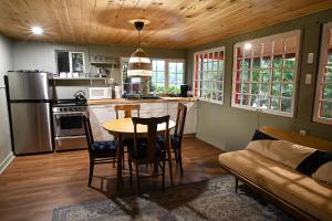 a kitchen with a table and chairs and a couch at Camp Hudson Pines in Corinth