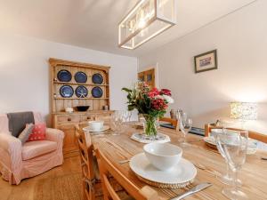 a dining room with a wooden table with flowers on it at 2 Bed in Fowey oc-91396 in Fowey +19 photos
