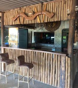 a wooden fence with two chairs and a kitchen at Estância Jockey Clube in Sao Jose do Rio Preto
