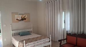 a bedroom with a bed and a chair and a window at Estância Jockey Clube in Sao Jose do Rio Preto