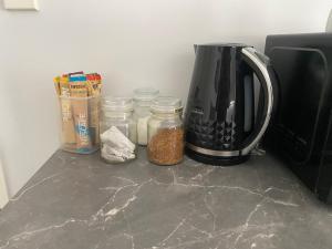 a counter with jars of food and a coffee maker at Union Street Hideaway in Waihi