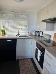 a kitchen with a sink and a dishwasher at 43 sea valley in Bideford