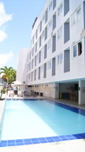 a swimming pool in front of a building at Praiano Flat Tambaú in João Pessoa