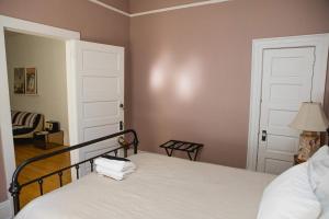 a bedroom with a bed with white sheets and a door at Object Hotel 2BR Room 2G in Bisbee