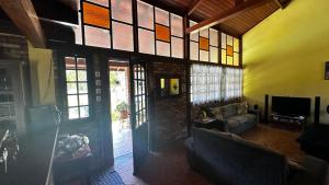 a living room with an open door and a couch at Sítio com piscina e lago in Salesópolis
