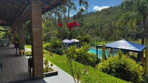 a view of a garden with a swimming pool at Sítio com piscina e lago in Salesópolis