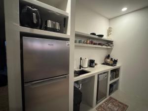 a small kitchen with a stainless steel refrigerator at SEA Villa With Private Plunge Pool in Todos Santos +16 photos