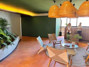 a room with chairs and a table and some people at BEE Suites Santa Ana - San Jose in San José