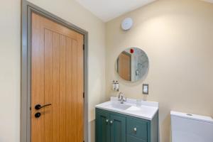 a bathroom with a sink and a wooden door at 1 Bed in Pershore oc-t29051 in Pershore +13 photos