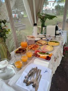 a table with a buffet of food and orange juice at Refugios de Rio Ilo in Concepción del Uruguay