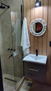 a bathroom with a shower and a sink and a mirror at Refugios de Rio Ilo in Concepción del Uruguay +6 photos