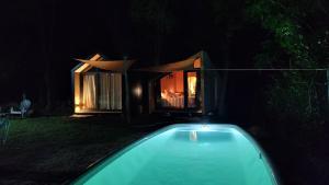 a swimming pool at night with a house in the background at Refugios de Rio Ilo in Concepción del Uruguay