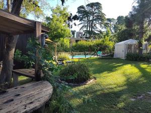 a yard with a wooden bench and a pool at Refugios de Rio Ilo in Concepción del Uruguay