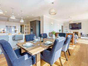 a dining room and kitchen with a wooden table and blue chairs at 3 Bed in Hythe oc-87167 in Hythe