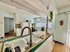 a kitchen with a sink and a counter top at Charming Bright 3BR House - Upper Level Suite in Burnaby