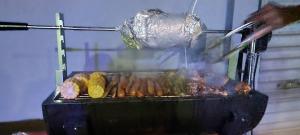 a person is cooking food on a grill at PEREGRINE Villa in Polonnaruwa