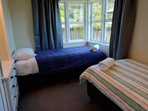 a bedroom with two beds and a window at Waitangi Beach Unit B in Paihia