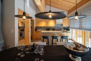 a kitchen with a table with wine glasses on it at Chalet Gutsch Andermatt in Andermatt