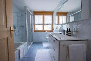 a bathroom with a tub and a sink and a shower at Chalet Gutsch Andermatt in Andermatt +20 photos