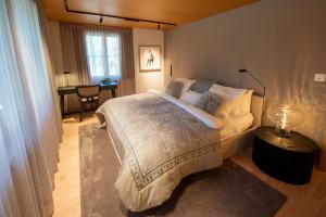 a bedroom with a large bed and a desk at Chalet Gutsch Andermatt in Andermatt