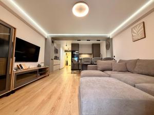 a living room with a couch and a flat screen tv at Sunny Waves Apartment in Cullera +24 photos