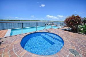 a large blue pool with a view of the water at Banyandah Towers in Maroochydore