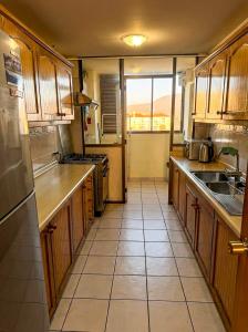 a kitchen with wooden cabinets and a tile floor at Departamento La Serena Vista al Mar in La Serena