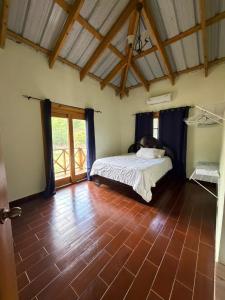a bedroom with a bed and a tiled floor at Villa Ana Rosa in Jarabacoa