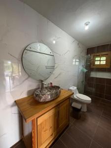 a bathroom with a sink and a toilet and a mirror at Villa Ana Rosa in Jarabacoa